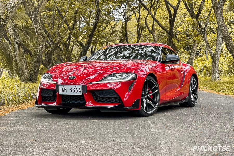 A picture of the Toyota Supra parked on a street surrounded by trees.