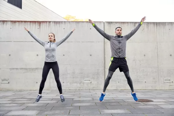 Two people doing jumping jacks
