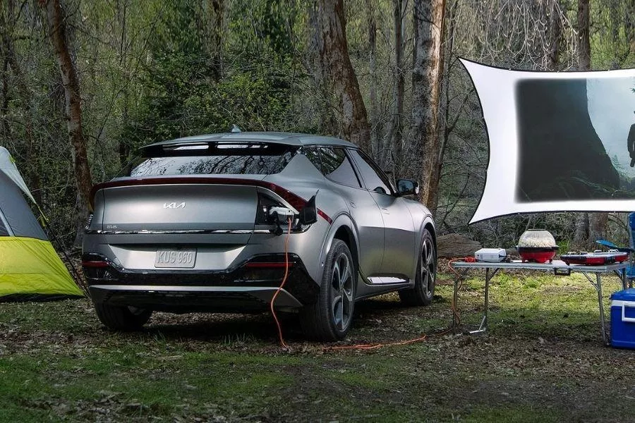 A picture of a Kia EV6 being used as a power source while camping.