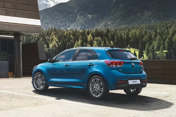 A blue Rio with a mountain in its background