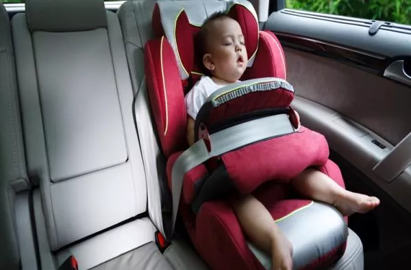 a child sleeping alone in a car