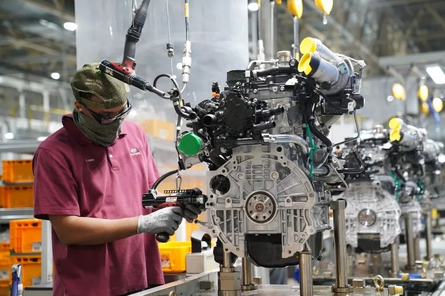 A picture of a Hyundai employee assembling an engine