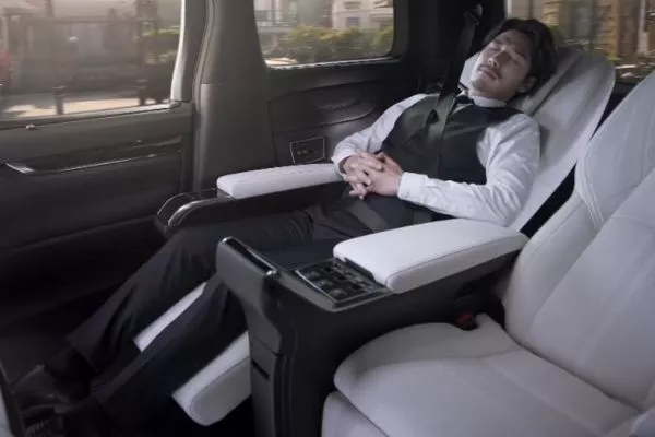 A picture of a man sleeping inside the Lexus LM