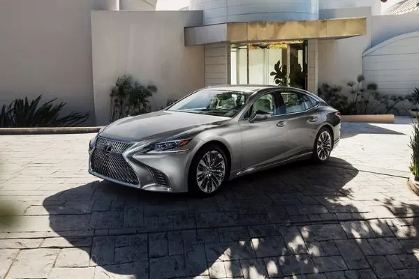 A gray LS sedan with a house at the back