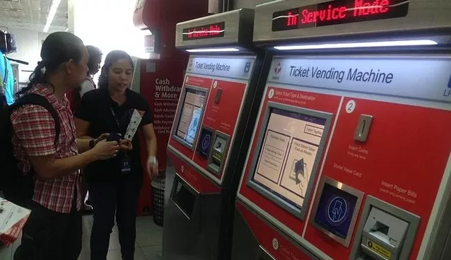 Two women using ticket vending machine