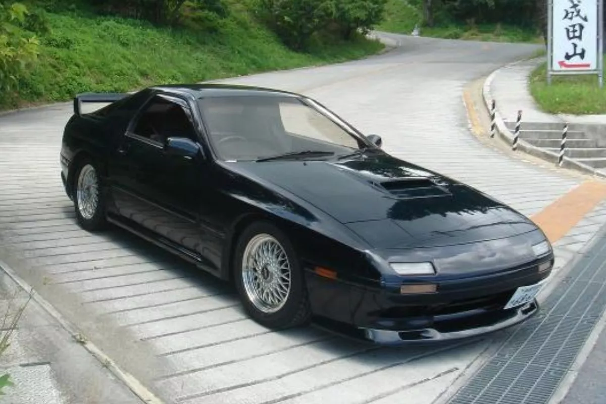 A picture of a MAzda RX-7 Infini III as it moves out of the driveway