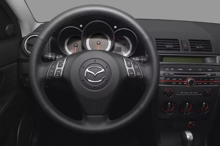 A look into the Mazda3 BK's interior particularly its steering wheel and steering wheel emblem A picture of the Mazda3 BK's