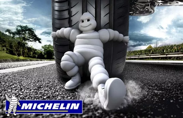 Photo of a Michelin's stuffed animal and a Michelin tire