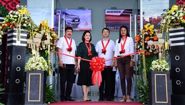 4 people taking pictures at the inauguration of the MMPC's new dealership