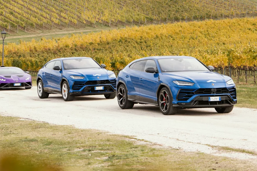 A picture of two Lamborghini Urus SUVs with mustache decals for Movember