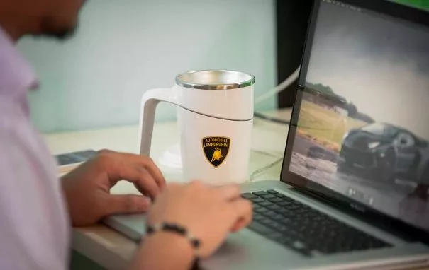 A man using his laptop and a Petron Lamborghini Anti-Spill Mug