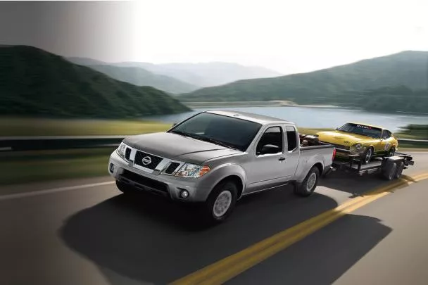 Nissan Frontier towing a coupe on the road