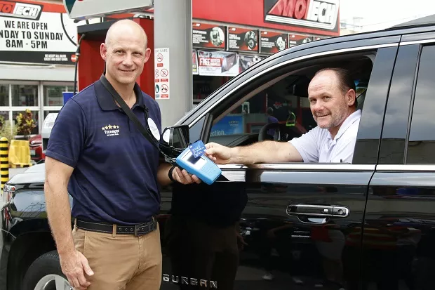 A motorist showing Caltex Visa payWave to a Caltex officer