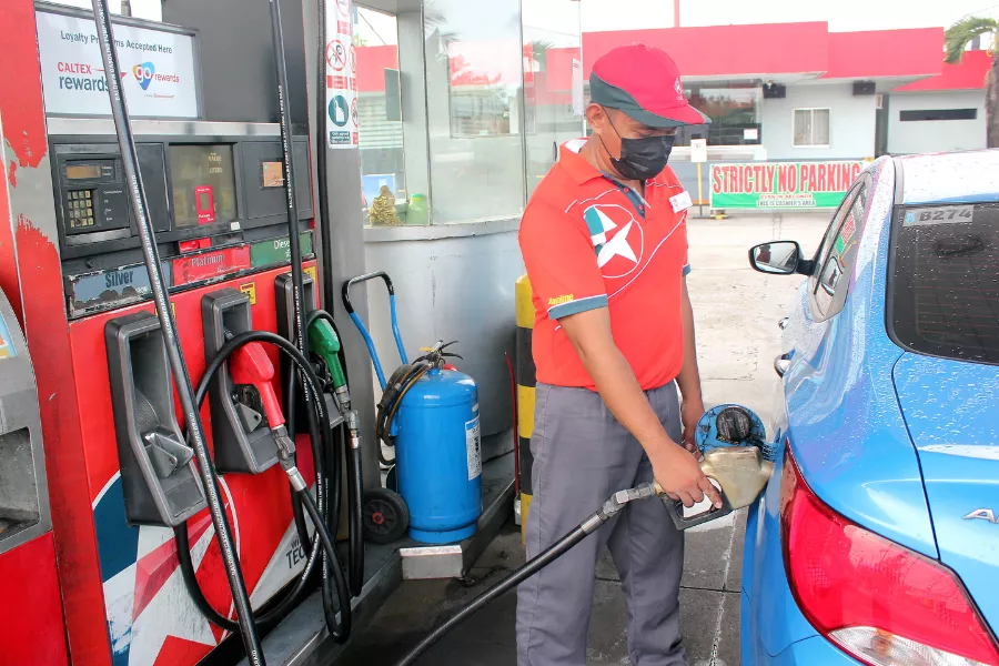 A picture of a fuel pump attendant fueling a car