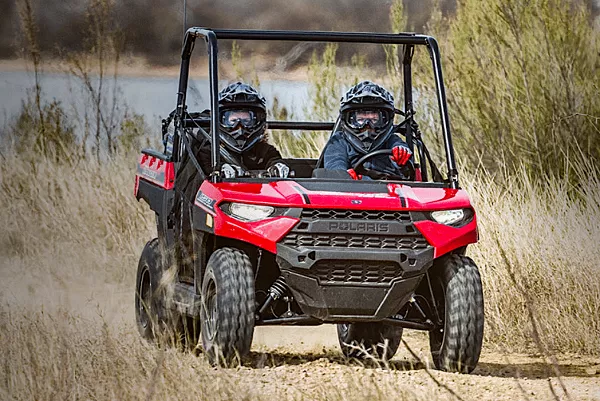 Two kids riding the Polaris Ranger 150