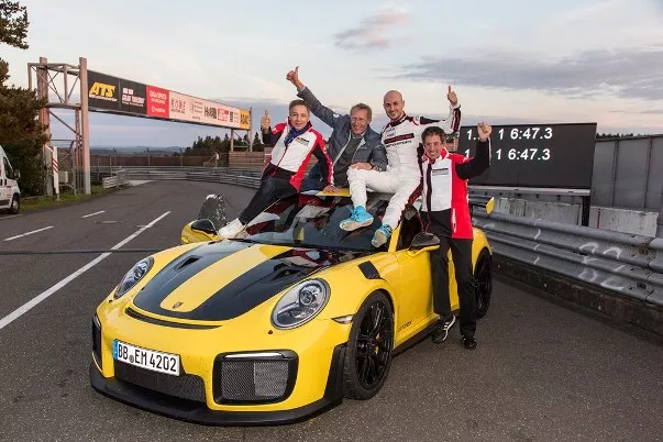 German race Lars Kern and 3 other men sitting on the top of a Porsche 911