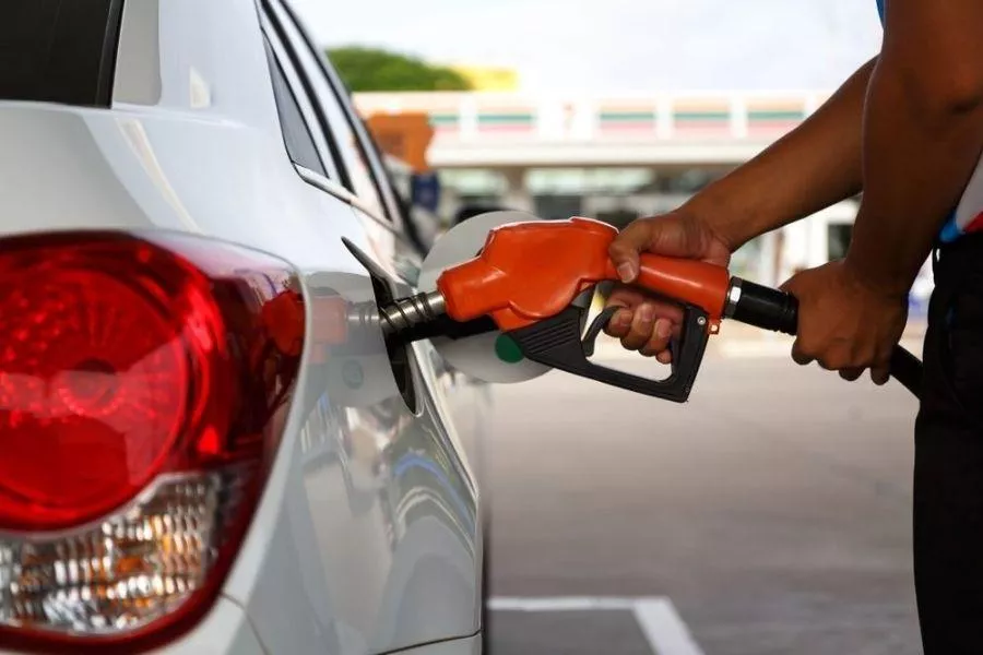 A picture of a person filling up a car