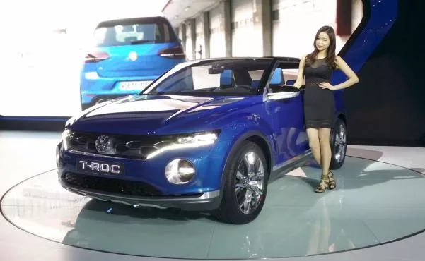 A promotion girl standing next to a VW T-Roc at the GIMS 2014