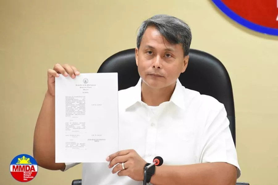 A picture of Atty. Cris Saruca Jr. showing a document.