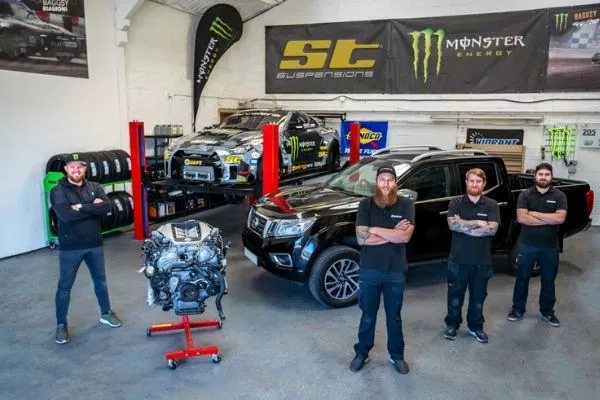 The SBMotorsport staff posing with a GT-R engine and the base Navara