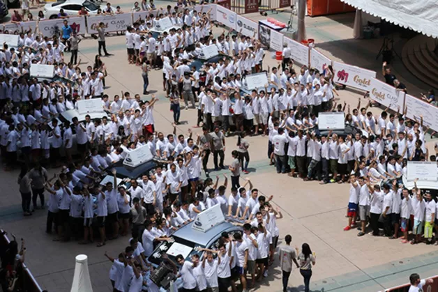 Hundreds of participants holding on to a Subaru car