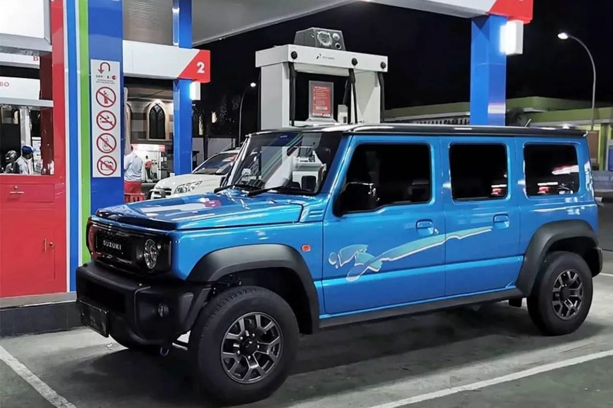 A blue 5-door vehicle in a gas station