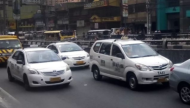 Three white regular taxis on the Phillippine road