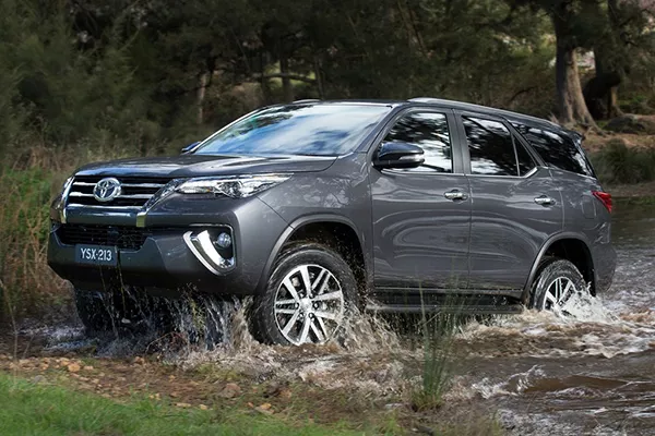 A Toyota Fortuner crossing a small creek.