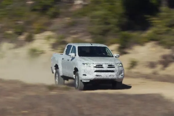 A camouflaged Hilux doing rally runs