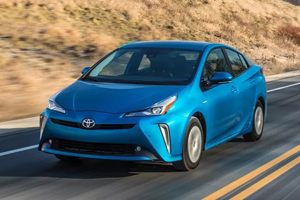 A picture of a blue Toyota Prius on the highway