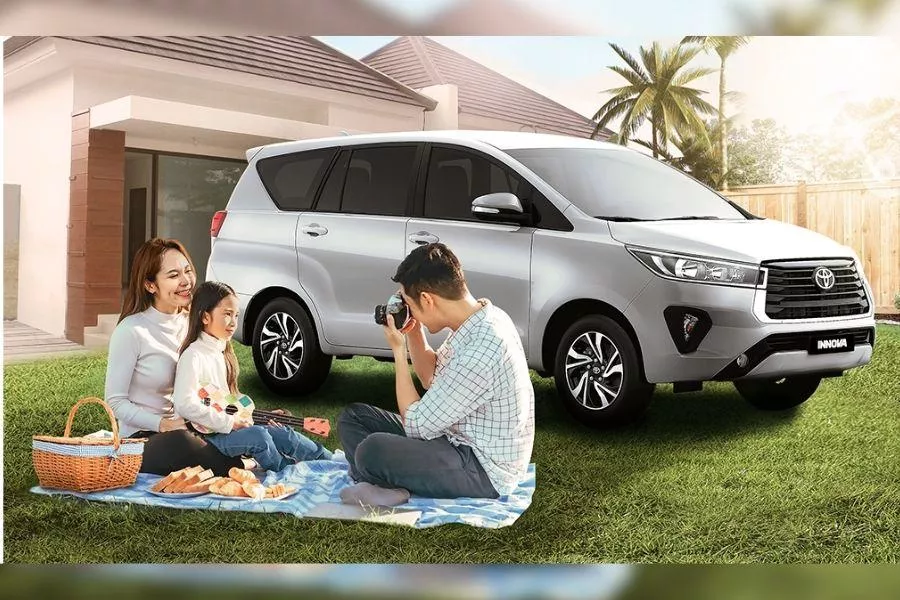 A picture of a family together with their Toyota Innova