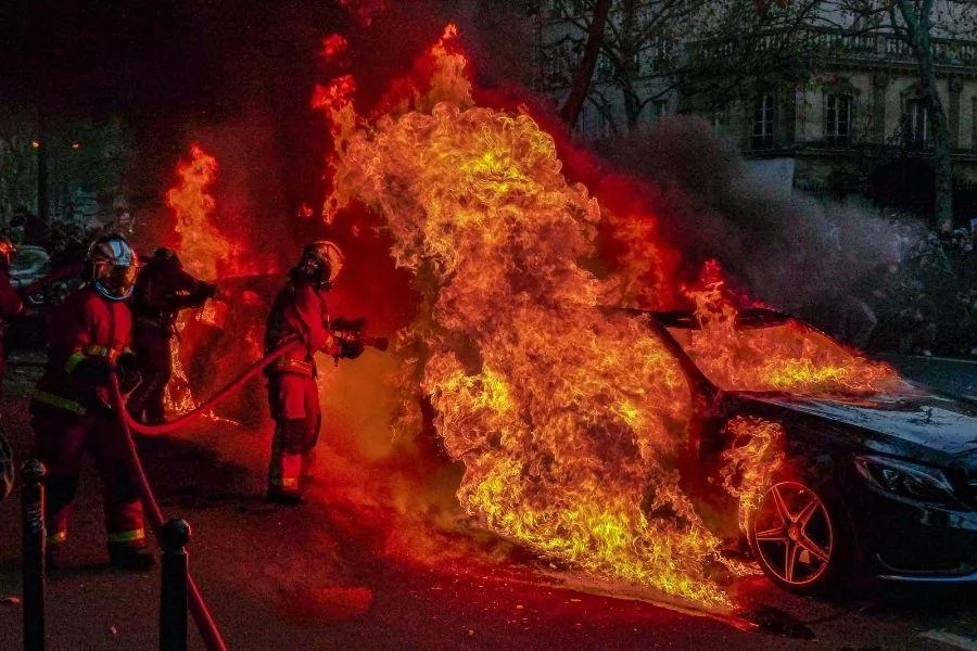 Firefighters with burning car
