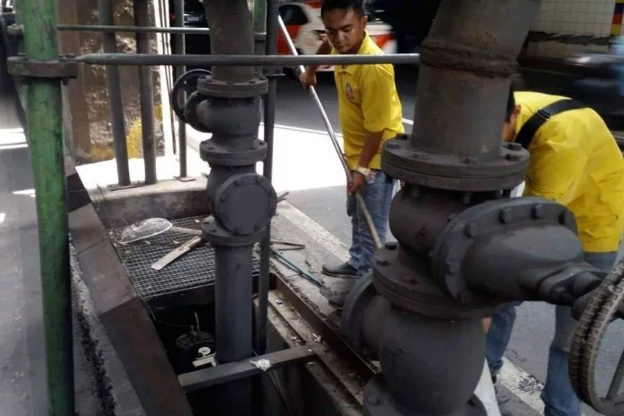 MMDA personnel cleaning flood pump 