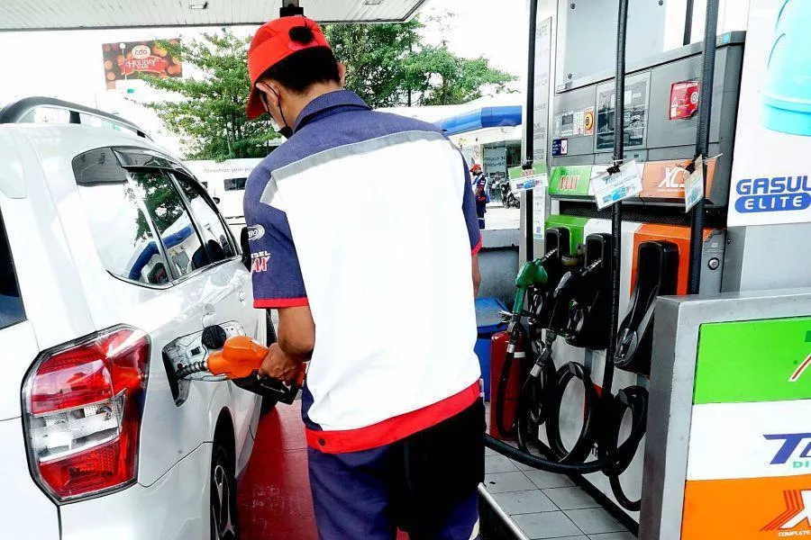 Gas station attendant pumping fuel 