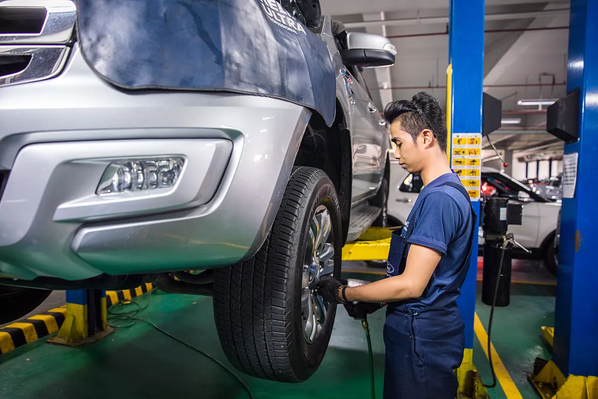 A picture of a technician checking a Ford SUV