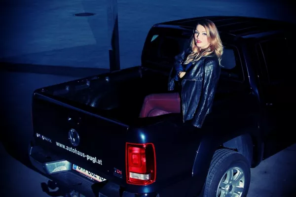 A woman sitting on the Volkswagen Amarok's trunk