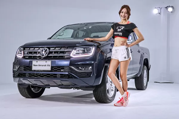 A Korean girl posing beside a Volkswagen Amarok