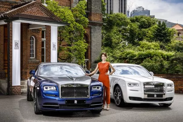 a Korean woman between a Rolls-Royce Ghost Seoul Edition & a Rolls-Royce Wraith Busan Edition