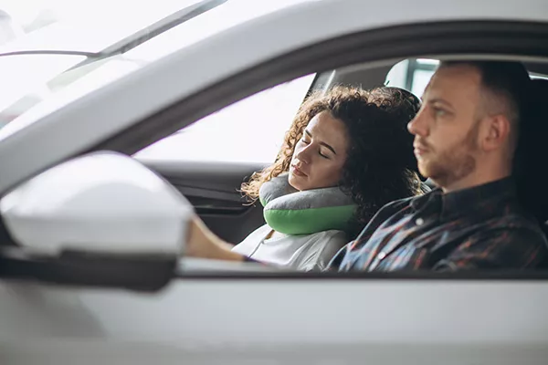 A picture of a woman using a neck pillow.