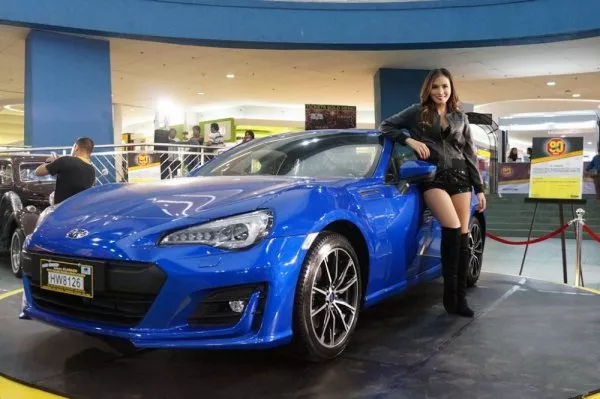 a Promotion Girl standing beside a car