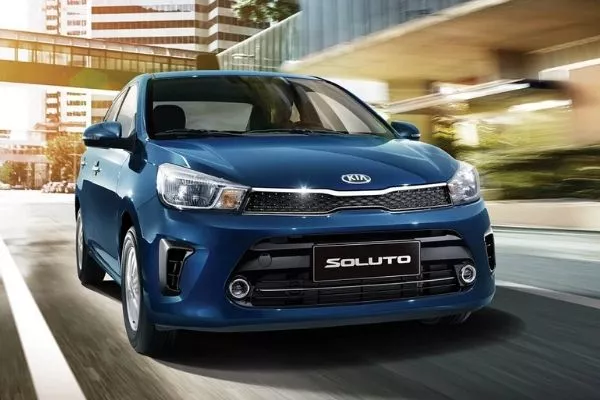 A picture of a blue Kia Soluto in the city