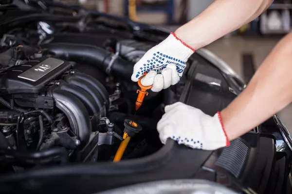 Man checking the engine oil of the car