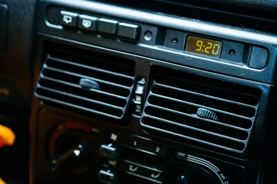 A car's a/c vents with a clock