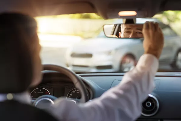 Man looking at the rear-view mirror