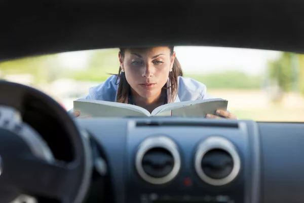 Woman reading car manual