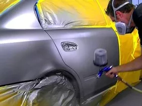 A man painting a car