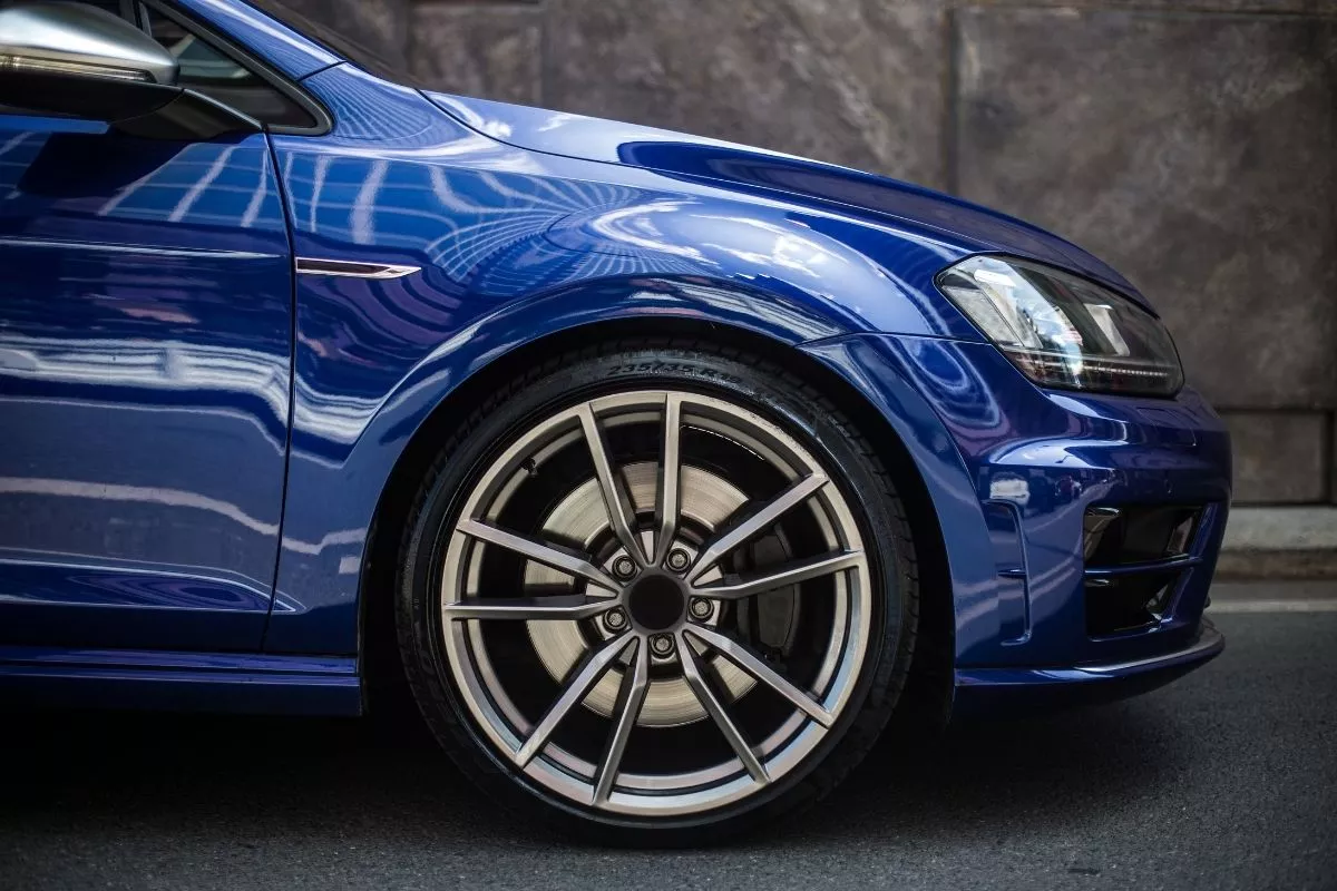 A picture a blue sedan and its wheels