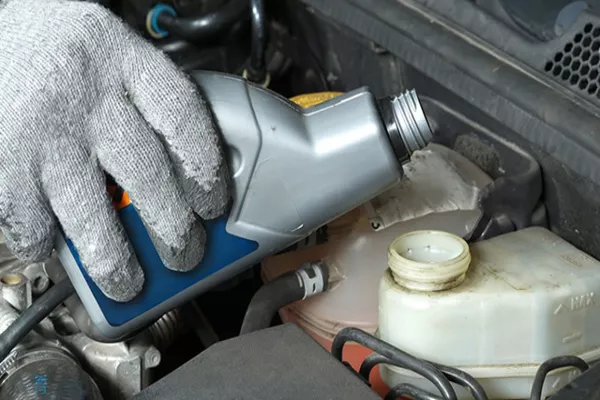Man putting brake fluid in the reservoir