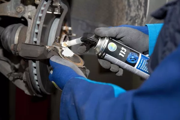 Man applying damping paste on the brake pads