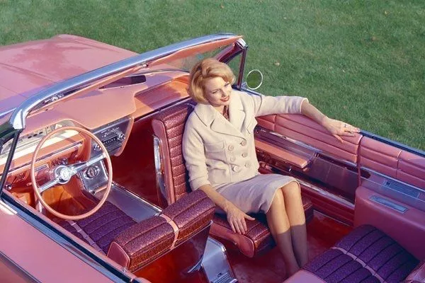 A picture of a pink Cadillac Flamingo with a passenger